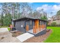 Charming exterior with a wooden porch and dark painted brickwork, all on a lush lawn at 3661 W Potomac Dr, East Point, GA 30344