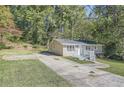 Charming home with a concrete driveway leading to the front entrance with surrounding trees and a lawn at 3459 Adkins Nw Rd, Atlanta, GA 30331