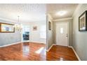 Bright dining room featuring hardwood floors, elegant chandelier, and view of adjacent kitchen area at 7740 Berea Rd, Winston, GA 30187