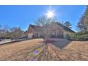 Exterior angle view of a traditional brick home with mature trees and landscaping at 1070 River Valley Dr, Dacula, GA 30019