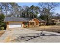 Exterior shot of a one-story home with a garage and a long, wide driveway at 992 Yemassee Trl, Stone Mountain, GA 30083