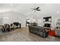 Open-concept living room featuring vaulted ceilings, wood floors, fireplace and a ceiling fan at 992 Yemassee Trl, Stone Mountain, GA 30083