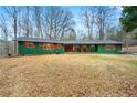 Charming single-story home boasts a welcoming front porch, vibrant color scheme, and mature trees at 13356 Panhandle Rd, Hampton, GA 30228