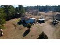 Scenic aerial view of a rural property showcasing a cozy home and outbuildings at 5570 Bold Springs Rd, Dacula, GA 30019