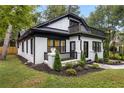 Beautiful two-story home with black trim, white painted brick, landscaped yard, and a rooftop deck at 645 Cumberland Rd, Atlanta, GA 30306