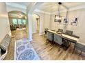 Bright dining room featuring wood flooring, modern lighting, and open floorplan at 91 Reynoldston Ct, Suwanee, GA 30024