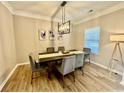 Well-lit dining area with wood floors, modern lighting, and neutral decor at 91 Reynoldston Ct, Suwanee, GA 30024