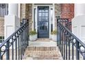 Inviting front entrance with brick steps, iron railings, and a black front door creating a welcoming entry point to the home at 5964 Reddington Way, Sandy Springs, GA 30328