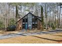 Charming brick home with blue door, surrounded by mature trees and a well-manicured lawn at 1605 Saint Tropez Way, Atlanta, GA 30350
