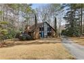 Charming brick home with blue door, surrounded by mature trees and a well-manicured lawn at 1605 Saint Tropez Way, Atlanta, GA 30350
