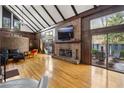 Inviting living room with a brick fireplace, hardwood floors, vaulted ceiling, and natural light at 1605 Saint Tropez Way, Atlanta, GA 30350