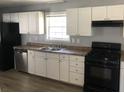 Updated kitchen with white cabinets, stainless steel dishwasher, and a black gas range stove at 5250 Hollyhock Rd, Douglasville, GA 30135