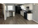 Bright kitchen featuring white cabinets, a black refrigerator and stove, plus updated flooring at 5250 Hollyhock Rd, Douglasville, GA 30135