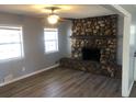 Cozy living room with a stone fireplace, ceiling fan, new floors, and large windows at 5250 Hollyhock Rd, Douglasville, GA 30135