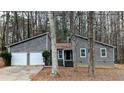Two-story home featuring a two-car garage, gray siding, and a small, neatly landscaped front yard at 3515 Weathered Wood Dr, Ellenwood, GA 30294