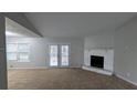 Spacious living room with high ceilings, a cozy stone fireplace, and sliding glass doors to the outside at 3515 Weathered Wood Dr, Ellenwood, GA 30294