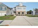 Two-story home featuring gray siding, brick accents, a long driveway and well-maintained landscaping at 2015 Wyndham Pl, Conyers, GA 30013