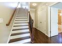 Elegant staircase featuring hardwood steps, iron balusters, and natural light streaming through an open doorway at 1365 Hawthorne Se Ave, Smyrna, GA 30080