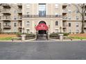 Elegant building entrance with a red awning, decorative ironwork, and manicured landscaping at 2865 Lenox Ne Rd # 410, Atlanta, GA 30324