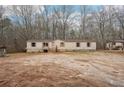 Home's exterior features beige siding, a wooden porch, and trees around at 90 Oak Ridge Dr, Carrollton, GA 30116