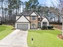 Beautiful two-story home featuring a stone facade, a two-car garage, and a green front yard at 9811 Spyglass Dr, Villa Rica, GA 30180