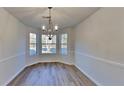 Bright dining area features three windows for great natural light and a stylish modern chandelier at 2822 Ward Lake Way, Ellenwood, GA 30294