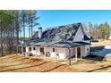 A covered backyard patio with ample space for seating, dining, and enjoying the outdoor scenery at 71 Presley Farm Ln, Rockmart, GA 30153