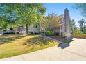 View of the home with a spacious yard and driveway and a partial brick wall at 1031 Steeple Run, Lawrenceville, GA 30043