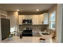 Modern kitchen features white cabinets, stainless steel appliances, and stylish countertops at 1055 Pinecrest Dr, Forest Park, GA 30297