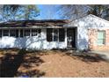 Charming single-story home with a painted white brick and dark shutters, offering timeless curb appeal at 6441 Holiday Blvd, Forest Park, GA 30297