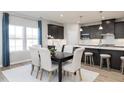 Kitchen and dining area with dark brown cabinets, island, and white dining chairs at 1141 Burlington Ct, Mcdonough, GA 30253