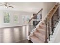 Bright living room featuring hardwood floors, large windows, and a staircase at 3877 Lockaby Way, Lawrenceville, GA 30044