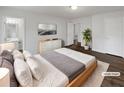 Staged bedroom with a large bed, modern dresser, and a view of the en-suite bathroom at 3764 Cherokee Overlook Dr, Canton, GA 30115