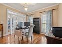 Well-lit home office with hardwood floors, a computer setup, and French doors leading to the dining room at 21 Cass Station Pass Nw Pass, Cartersville, GA 30121