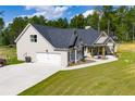 Side view of a single-Gathering home featuring a two-car garage and manicured front lawn at 1291 Pleasant Grove Church Rd, Villa Rica, GA 30180