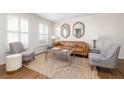 Comfortable living room with a leather sofa, hardwood floors, and decorative mirrors at 834 Heritage Sq, Decatur, GA 30033