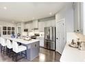 Bright kitchen boasts stainless steel appliances, quartz countertops, and a large center island with seating at 1148 Burlington Ct, Mcdonough, GA 30253
