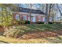 Beautiful brick home featuring a well-manicured lawn, mature trees, and charming architectural details at 3587 Coldwater Canyon Ct, Tucker, GA 30084