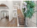 Bright foyer featuring hardwood floors, staircase, and decorative holiday wreath at 1323 Champion Run Dr, Dacula, GA 30019