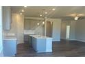 Open-concept kitchen with an island, modern cabinetry, stainless steel sink, and elegant pendant lighting at 822 Kestrel Dr, Loganville, GA 30052