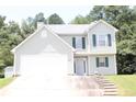Charming two-story home with gray siding, green shutters, attached two-car garage, and small front yard at 5627 Isleworth Ct, Atlanta, GA 30349