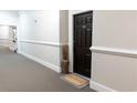 Neutral hallway featuring a dark wood front door with a Welcome mat, leading to various exits at 11 Perimeter E Ctr # 1203, Dunwoody, GA 30346