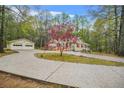 Ranch style home and detached garage with a decorative tree in the front yard at 125 Bridget Dr, Hampton, GA 30228