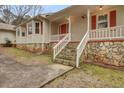 Charming home entrance with stone accents, white railing, and red door at 125 Bridget Dr, Hampton, GA 30228