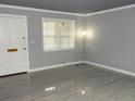 Bright living room with window, light gray walls, and wood-look tile floors at 3083 Colonial Way # N, Atlanta, GA 30341