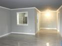 Open living room with gray paint, wood-look tile floors, and view into the kitchen at 3083 Colonial Way # N, Atlanta, GA 30341