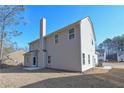 Back of home featuring neutral siding, a chimney, and a concrete patio space for entertaining at 455 Charleston Pl, Villa Rica, GA 30180