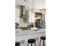 Close up of a kitchen with stainless steel hood and appliances, white subway tile backsplash, and breakfast bar seating at 22 Airline Ne St # 403, Atlanta, GA 30312