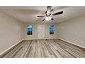 Spacious living room with ceiling fan, hardwood floors, large windows, and neutral paint at 640 City Park Dr, Mcdonough, GA 30252