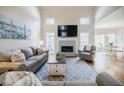 Comfortable living room with high ceilings, fireplace, sofa, armchairs, and ample natural light at 5355 Avonshire Ln, Cumming, GA 30040